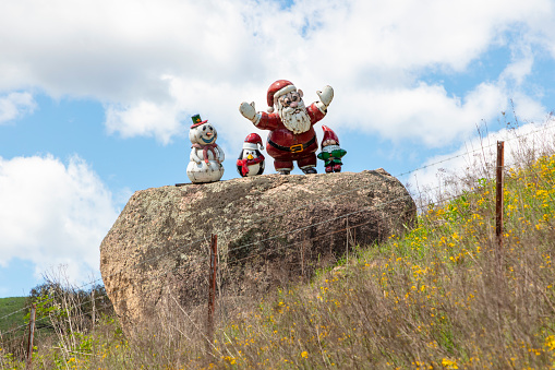 Photograph of some Christmas related small statues on a large rock in bushland in regional Australia