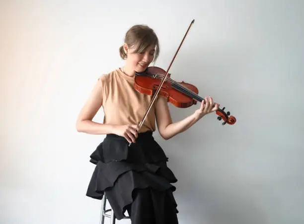 Photo of Woman playing violin with happy feeling,practice acoustic instrumen