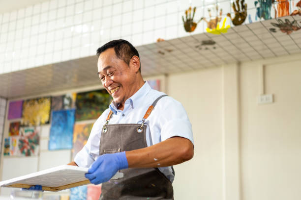 4K Asian senior man learning acrylic pouring art.