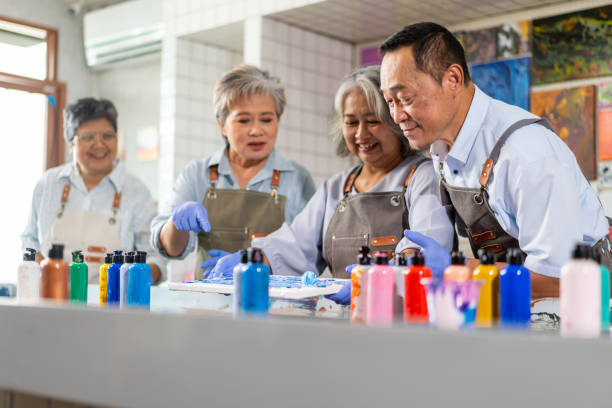 4K Group of Asian senior people learning acrylic pouring art together. 4K Group of Happy Asian senior people learning acrylic pouring art workshop at art studio. Elderly retired man and woman enjoy and fun with colorful abstract modern art painting in classroom. abstract oil painting for beginners stock pictures, royalty-free photos & images