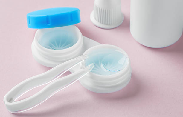 istock Contact lenses in case with solution liquid and tweezer on pastel pink background 1903742525
