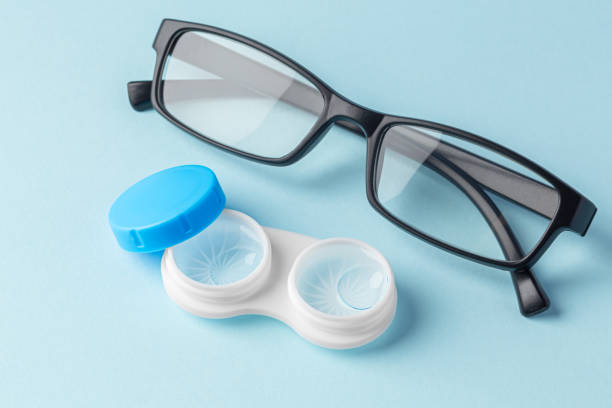 istock Contact lenses in case with solution liquid with eyeglasses on light blue background 1903743031