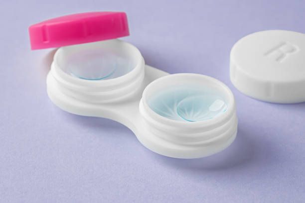 istock Cleaning contact lenses with solution liquid in case on pastel purple background 1903743034