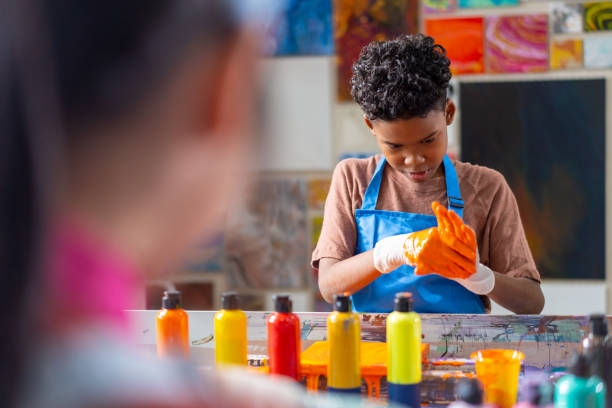 istock Group of Diversity school children learning acrylic art together in art class. 1903747143