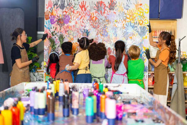 Group of Diversity school children learning acrylic art together in art class. Group of Diversity school children learning acrylic art on canvas frame workshop with teacher at art studio. Happy boys and girls enjoy and fun with colorful abstract modern art painting in classroom. asian kids learning stock pictures, royalty-free photos & images