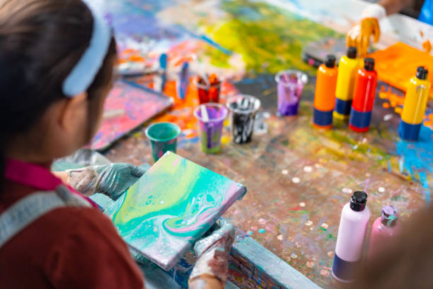 Group of Diversity school children learning acrylic art together in art class. Group of Diversity school children learning acrylic pouring art on canvas workshop with teacher at art studio. Happy boys and girls enjoy and fun with colorful abstract modern art painting in classroom. abstract oil painting for beginners stock pictures, royalty-free photos & images