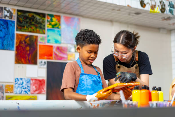 Group of Diversity school children learning acrylic art together in art class. Group of Diversity school children learning acrylic pouring art on canvas workshop with teacher at art studio. Happy boys and girls enjoy and fun with colorful abstract modern art painting in classroom. abstract oil painting for beginners stock pictures, royalty-free photos & images