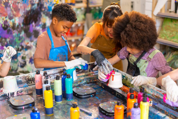 istock Group of Diversity school children learning acrylic art together in art class. 1903748695