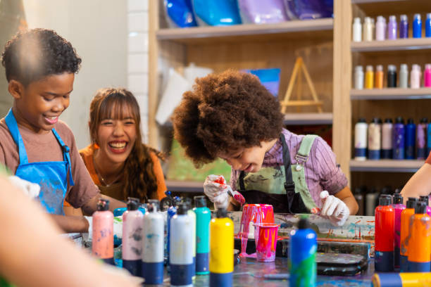 istock Group of Diversity school children learning acrylic art together in art class. 1903749718