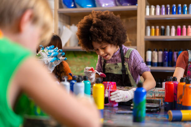 istock Group of Diversity school children learning acrylic art together in art class. 1903749719