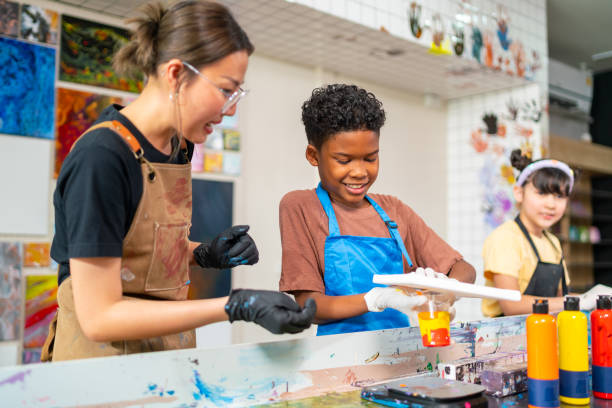 istock Group of Diversity school children learning acrylic art together in art class. 1903749723