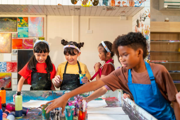 istock Group of Diversity school children learning acrylic art together in art class. 1903750232