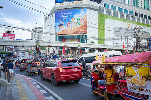 Bangkok, Thailand - Dec 04, 2023: Popular Tuk Tuk taxi car in busy Bangkok streets