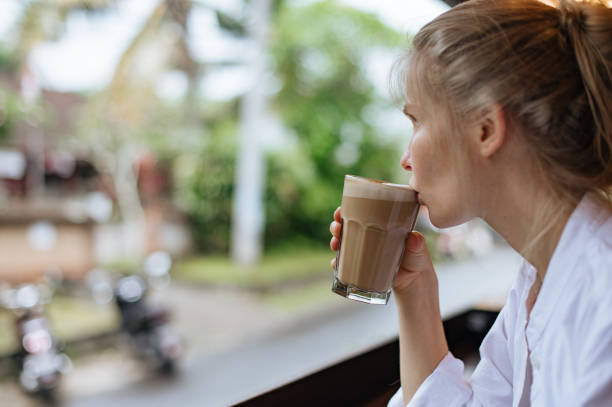 istock Girl drinking coffee and looking outside 1903758088