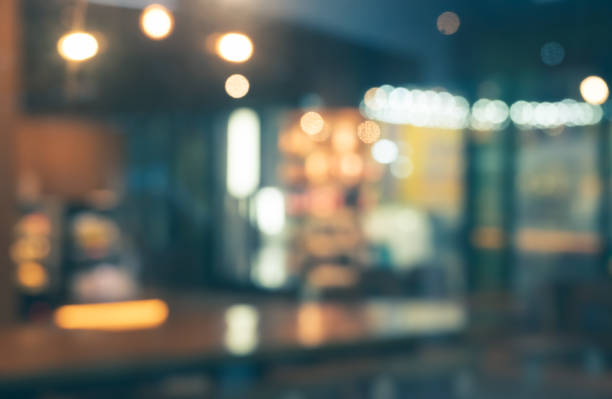 Coffee shop blur background with bokeh night lights Blurred of coffee shop and restaurant with bokeh coloful night lights background office window night stock pictures, royalty-free photos & images