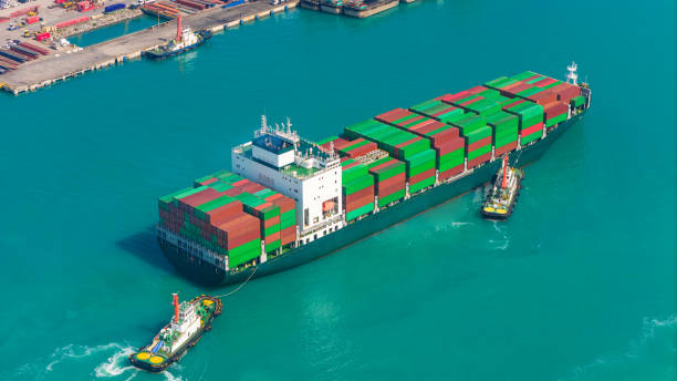 istock Aerial side view of cargo ship carrying container and running for export goods from cargo yard port to custom ocean concept technology transportation. 1903777638