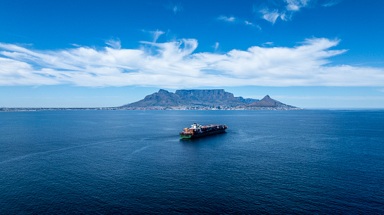 A container ship approaching Cape Town’s Table Bay harbour on a blue day.