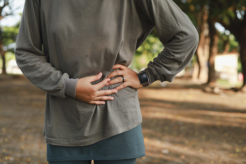 Side stitch - Jogging asian muslim woman with stomach side pain after jogging work out