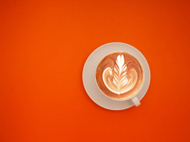 istock Top view of a fresh coffee cup on an orange background. 1903879085