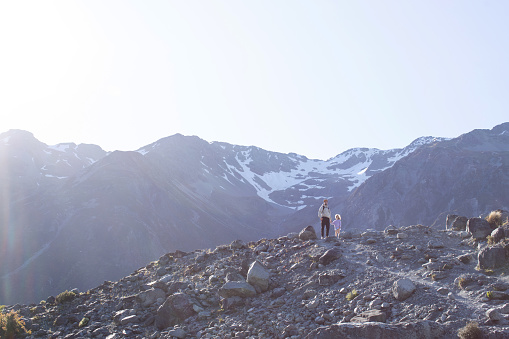 Dad and daughter travel through the mountains in New Zealand. The concept of travel, family active recreation.