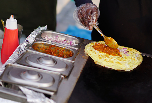 Close-up view of Indian stree food vendor making Vegetable Frankie