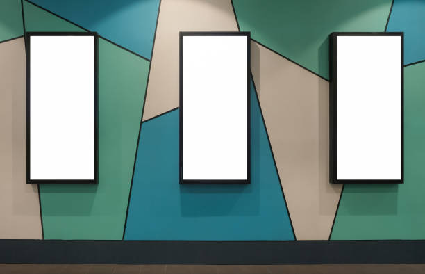 istock Multiple vertical advertising blank mockups on patterned wall. Indoors OOH out of home template. 3 poster frames with lighting and shadows, with clipping path 1903946604