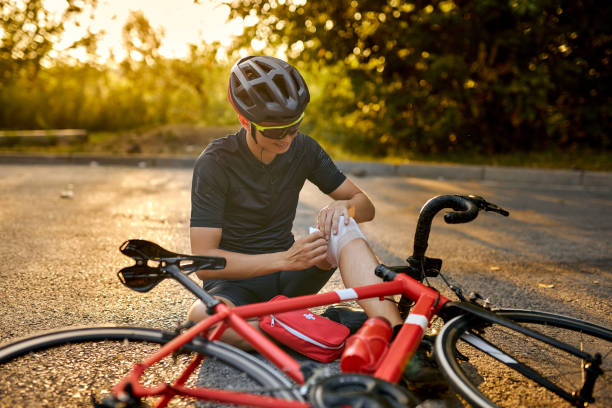 istock biker fell from bike, using bandage from first aid kit to help himself. Bicycle accident. 1903952872