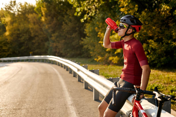 istock cyclist man drinking water while resting after intensive driving a bike, cheerful cyclist 1903953435