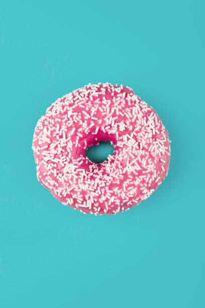istock Pink donut on color background, flat lay, top view 1903965080