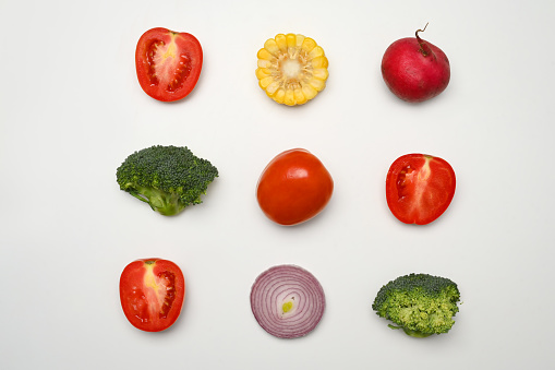 Sliced different fresh vegetables on white background. Healthy food, vegetarian and nutrition concept
