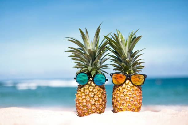 istock Two pineapples with trendy sunglasses in tropical paradise 1903988285