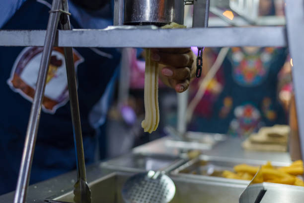 istock Person preparing churros at a street stall. 1903989331