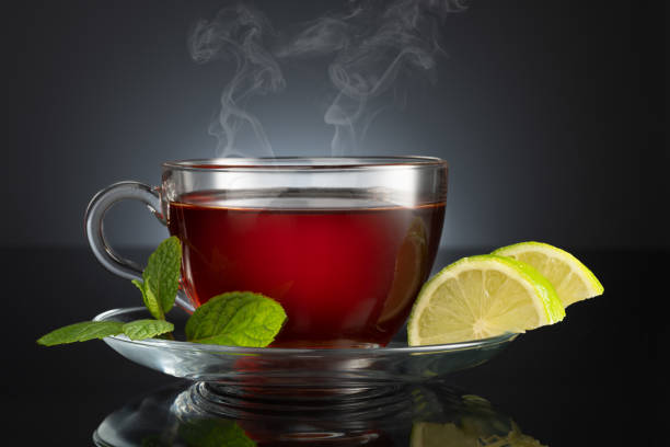 黒い背景にライムとミントとお茶のカップ - hot drink tea black tea red ストックフォトと画像
