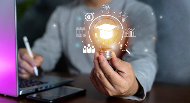 istock Hand showing graduation hat icon in light bulb. Internet education course degree and study knowledge. Creative thinking idea with goal. 1904035594