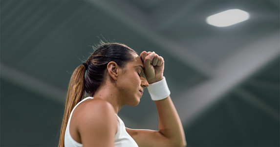 Female tennis player disappointed after failing match.
