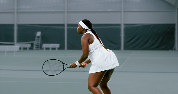 Female tennis player playing match in tennis court.