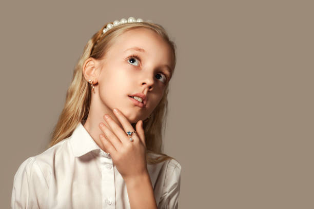 A beautiful girl looks at the camera and picks her nose. selective focus