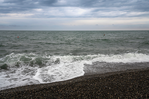 Black Sea on the Sochi coast and a pebble beach on a sunny day with clouds, Sochi, Krasnodar Territory, Russia