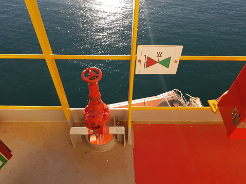 Pipes and valves on the deck of a ship in the open sea.