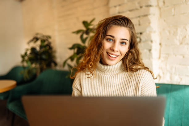istock Happy woman working with laptop in cafe. 1904164812