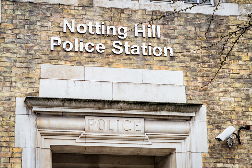 Signs above the entrance to Notting Hill Police Station in London, England.