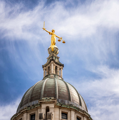 A gilded statue of Lady Justice on the dome above the Central Criminal Court building in central London. The court is commonly named the Old Bailey, after the location's street name.