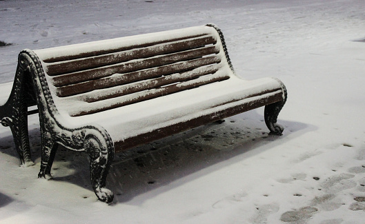 City benches in winter covered with snow
