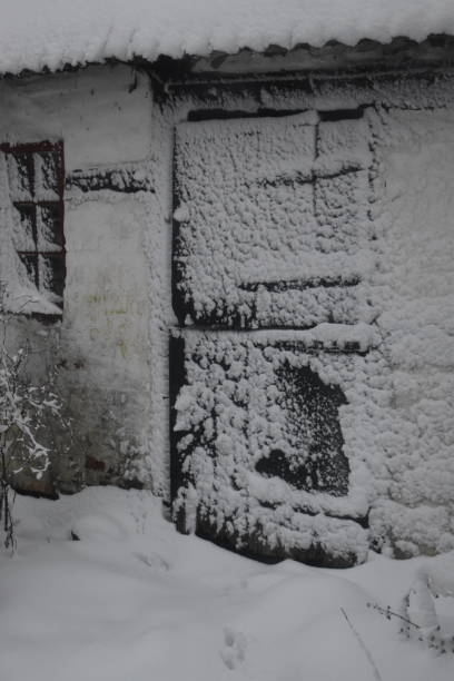 istock Old stable door and window covered in snow. 1904242793