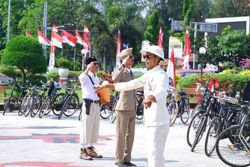 “Semarang, Indonesia – August 17, 2022 : The antique bicycle community held a Flag Ceremony during the commemoration of the independence day of the Republic of Indonesia in the Tugu Muda monument area, Semarang, Indonesia\