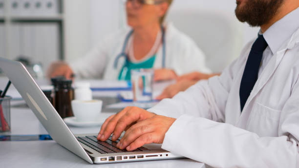 istock Man doctor using laptop writing treatment informations 1904274678