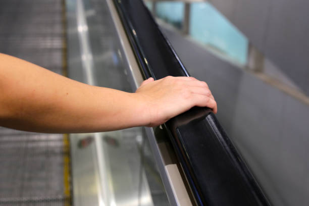 istock Hand holding escalator handrail in shopping mall or building 1904307434