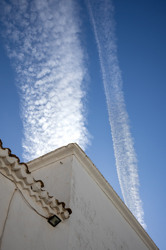 Deetails of the traditional spanish architecture with a white facade. Bright blue sky with contrast white chemtrails. Teguise, Lanzarote, Canary Islands, Spain.
