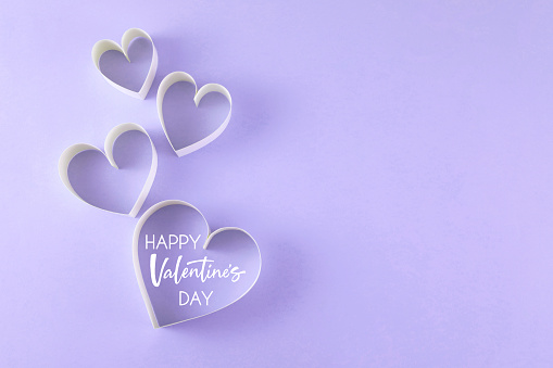 Heart shaped papers on pink background with Valentine’s day message and copy space