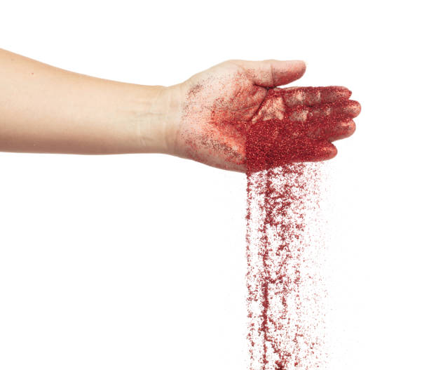 istock Red metallic glitter sparkle fall from hand. Red Glitter sand spark blink celebrate Chinese new year, particle pour from hand. White background isolated, selective focus Blur bokeh 1904348396